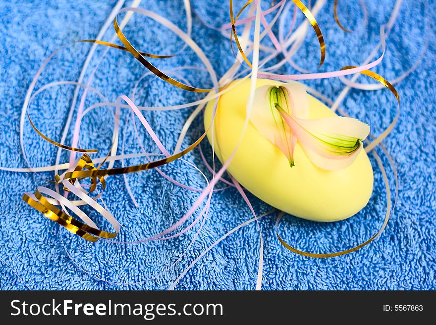 Soap and floral petal on blue fabric background