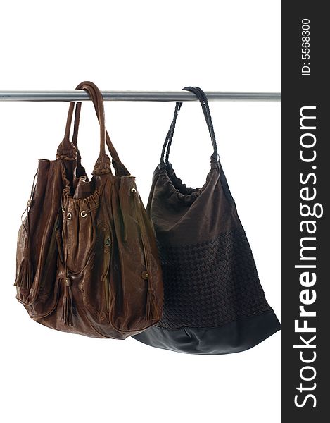 Two Fashionable handbags hanging on white background