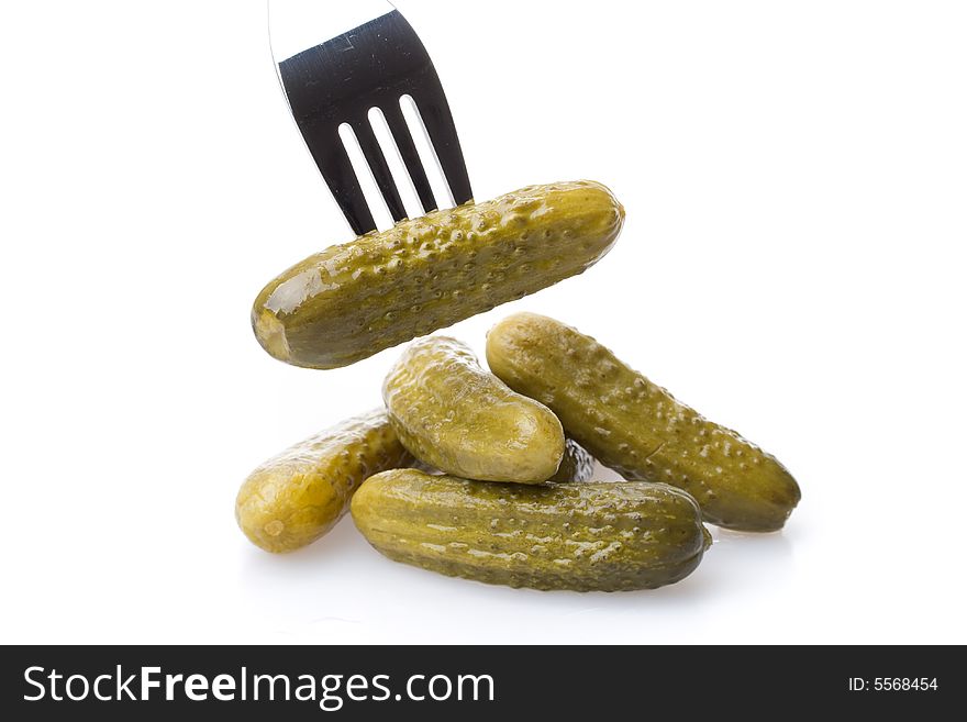 Crackling pickled gherkins on a plug on a white background