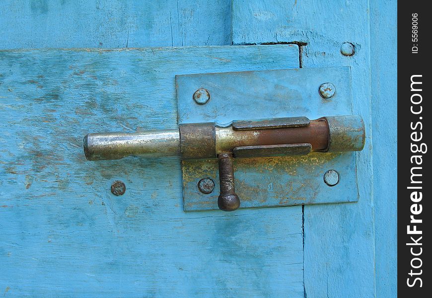 An old lock on a blue door