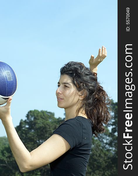 A young, attractive woman is getting ready to spike a volleyball at the park. Vertically framed shot. A young, attractive woman is getting ready to spike a volleyball at the park. Vertically framed shot.