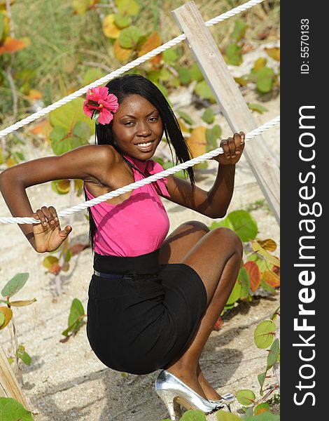 Woman squatting and posing by a rope. Woman squatting and posing by a rope.