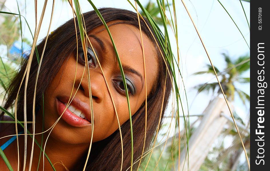 Headshot of a woman with palm fronds in front of her face. Headshot of a woman with palm fronds in front of her face