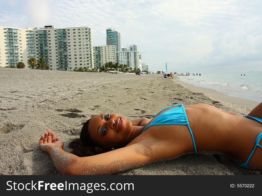 Young attractive woman laying on the sand