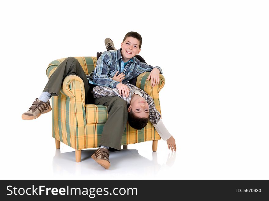 Two young happy smiling boys playing in the chair. Two young happy smiling boys playing in the chair