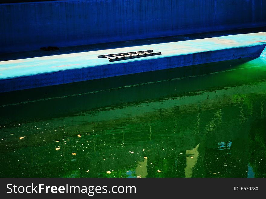 A dirty swimming pool in green color.