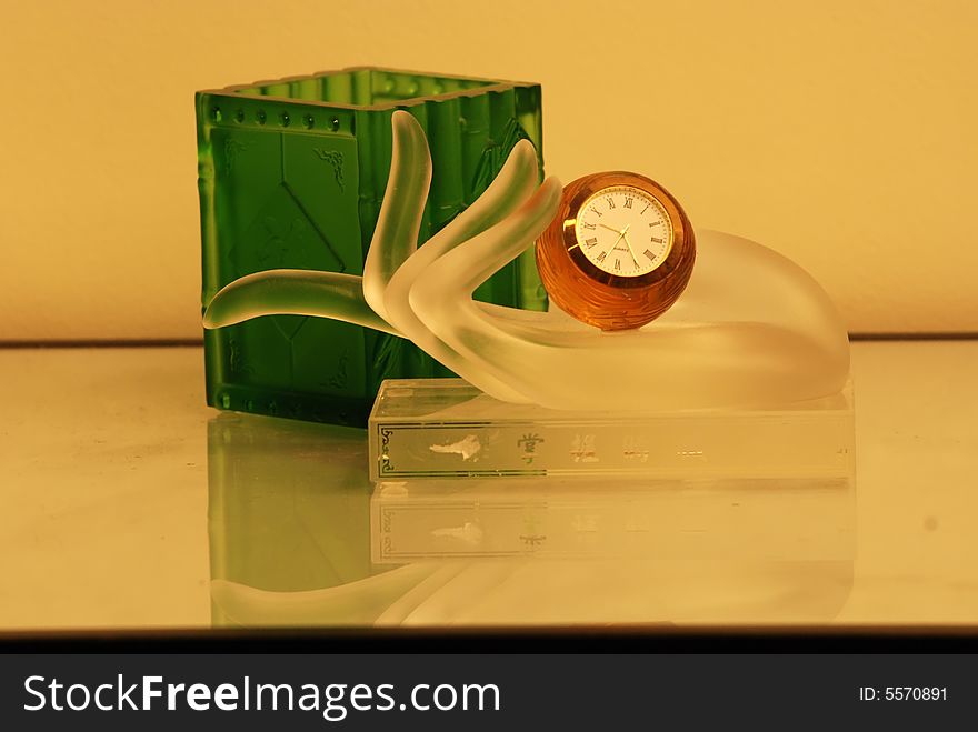 Crystal cup, clock and hand on the tables