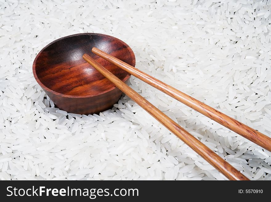 Closeup view of chopsticks and bowl on rice background. Closeup view of chopsticks and bowl on rice background