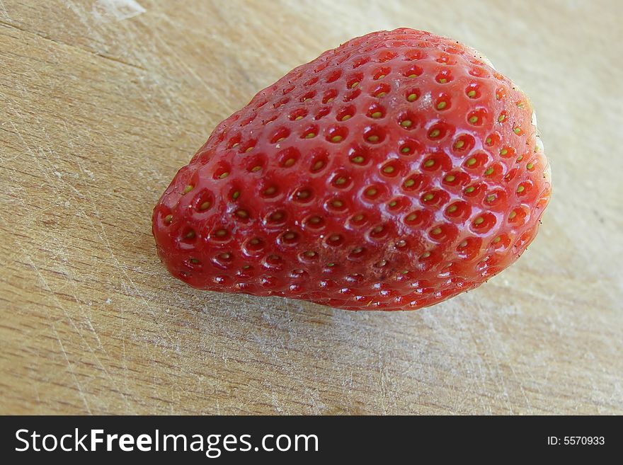 Single strawberry close-up image, isolated on a wooden board

*RAW format available