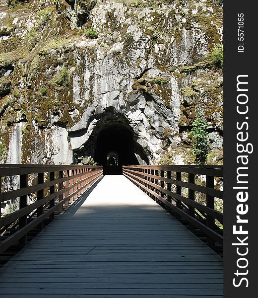 Deep tunnel in a rock with bridge