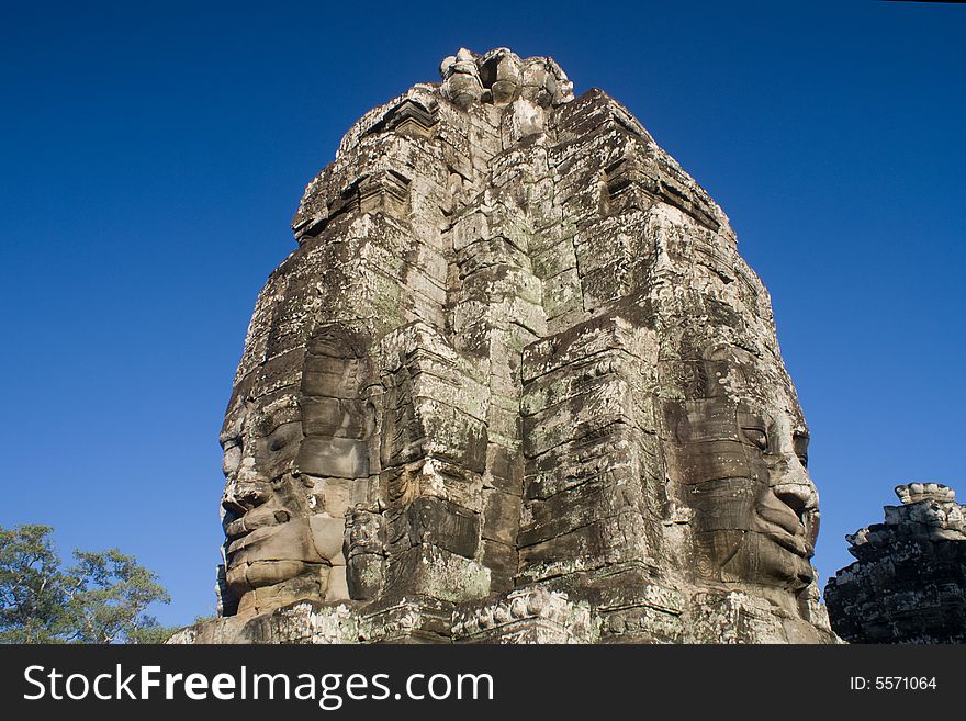 Huge buddha' faces in cambodia under very blue sky. Huge buddha' faces in cambodia under very blue sky