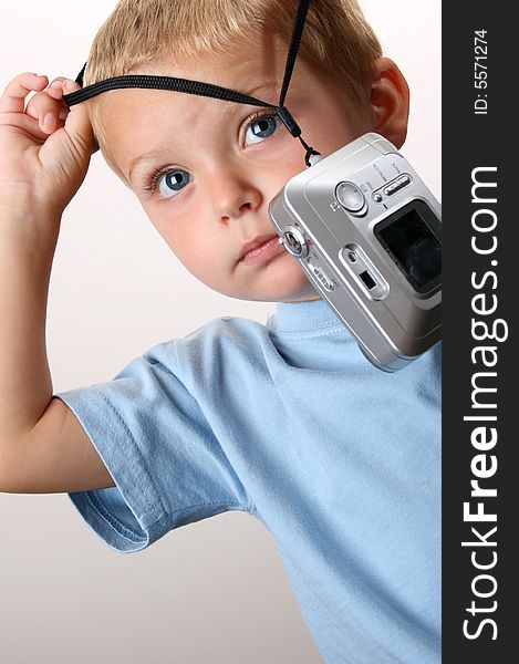 Toddler trying to hang the camera round his neck. Toddler trying to hang the camera round his neck