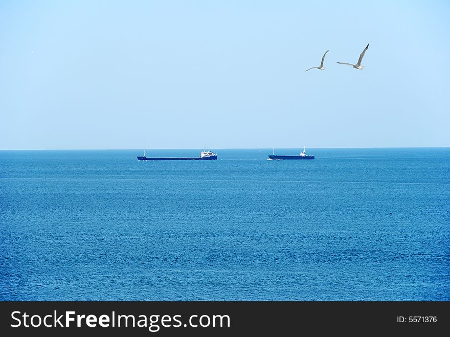 Commersial ships go to sea over blue sky. Commersial ships go to sea over blue sky