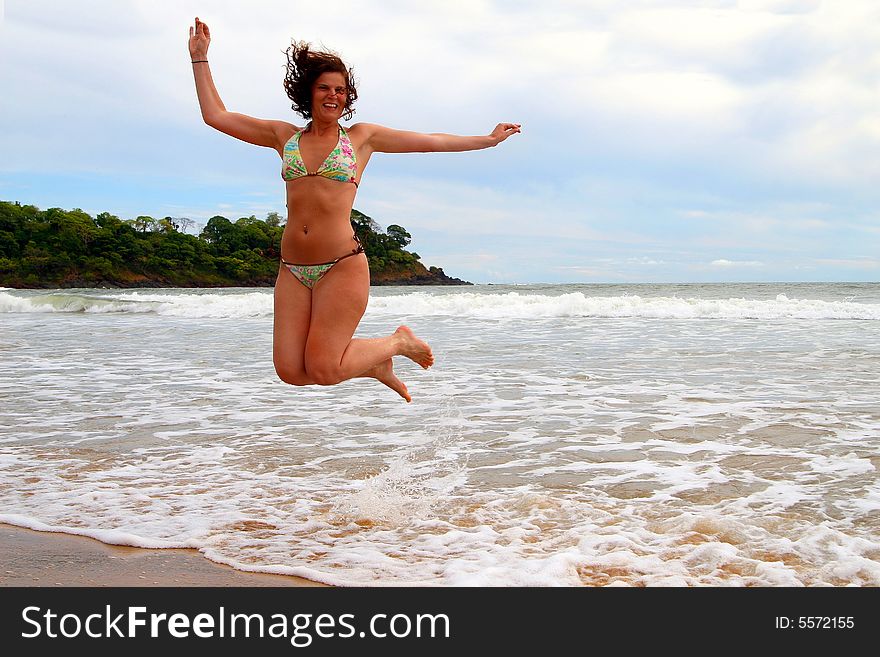 Young beautiful woman at the beach enjoying the sun and jumping for joy. Ideal summer / vacation shot. Young beautiful woman at the beach enjoying the sun and jumping for joy. Ideal summer / vacation shot.