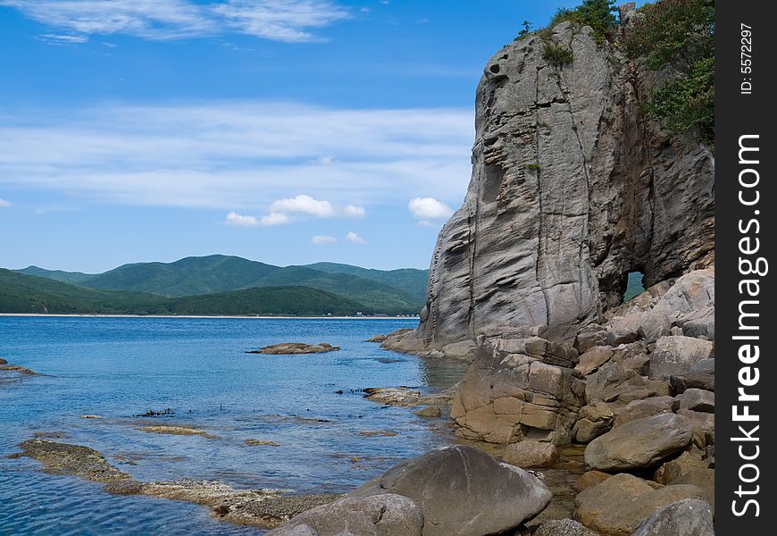 A very small bay among fancy rocks. Seacoast of Petrova island - pearl of nature state reserve Lazovsky. Russian Far East, Primorye. A very small bay among fancy rocks. Seacoast of Petrova island - pearl of nature state reserve Lazovsky. Russian Far East, Primorye.