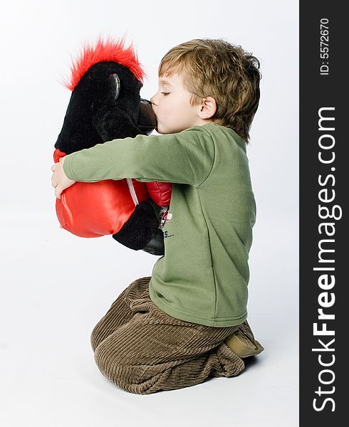 Boy kissing a toy gorilla. Boy kissing a toy gorilla