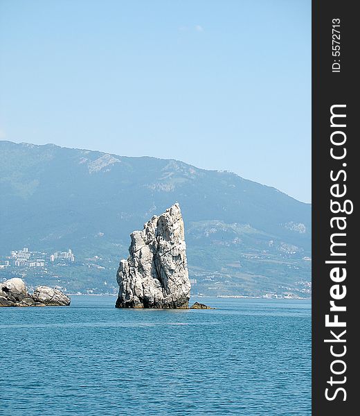 Isolated rock in the blue sea. Isolated rock in the blue sea