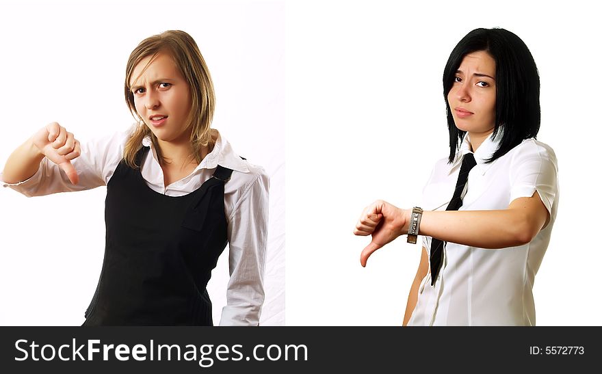 Two elegant businesswomen colleagues are giving the thumbs down and they are sad. They are wearing stylish shirts. Two elegant businesswomen colleagues are giving the thumbs down and they are sad. They are wearing stylish shirts.