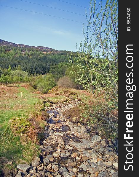 A rocky stream runs through glen ogle in scotland. A rocky stream runs through glen ogle in scotland