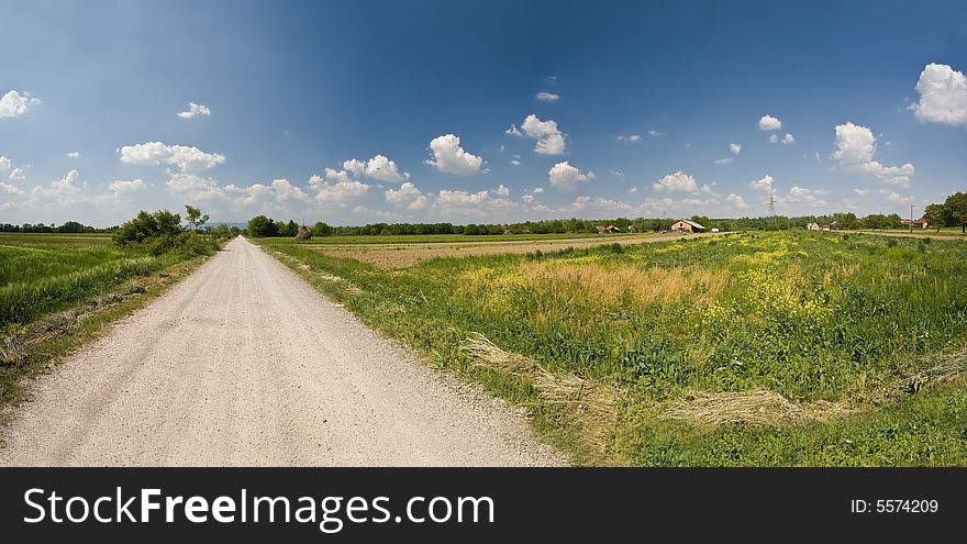 Path with field and white clouds