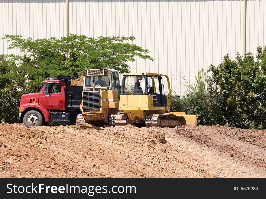 Heavy construction equipment and a dump truck on dirt. Heavy construction equipment and a dump truck on dirt