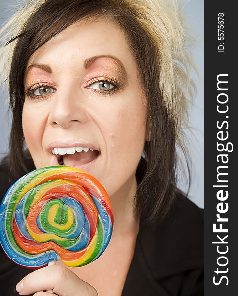 Portrait of a creative businesswoman with wild hair holding a lollipop. Portrait of a creative businesswoman with wild hair holding a lollipop