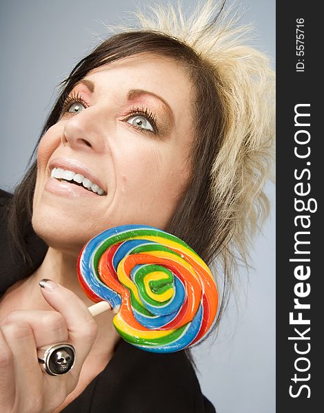 Portrait of a creative businesswoman with wild hair holding a lollipop. Portrait of a creative businesswoman with wild hair holding a lollipop