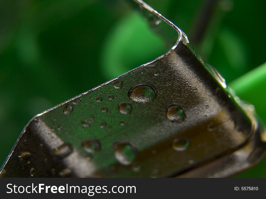 Metal parts covered by drops on the green background