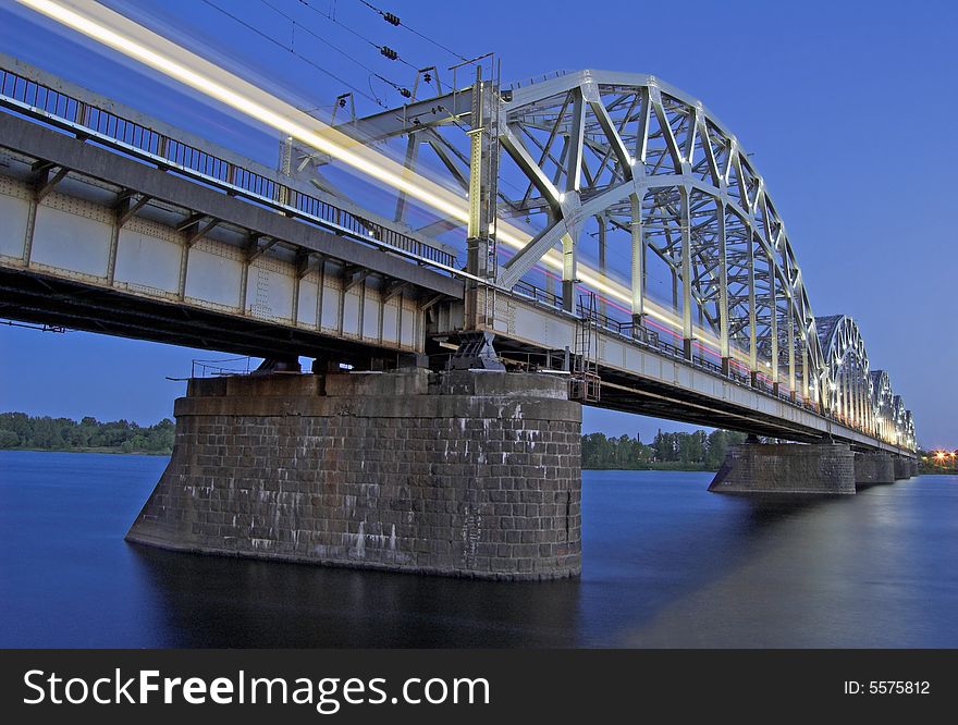 The night express train on the bridge across Daugava river. The night express train on the bridge across Daugava river.