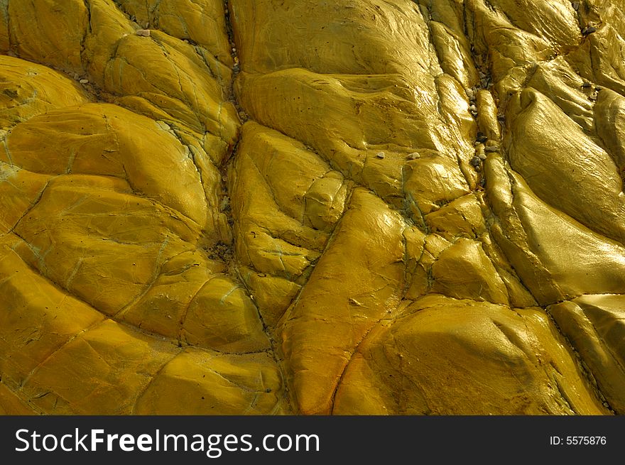 A closeup of wet sandstone rock by the seashore. Lit from the side. Suitable for abstract background. A closeup of wet sandstone rock by the seashore. Lit from the side. Suitable for abstract background.