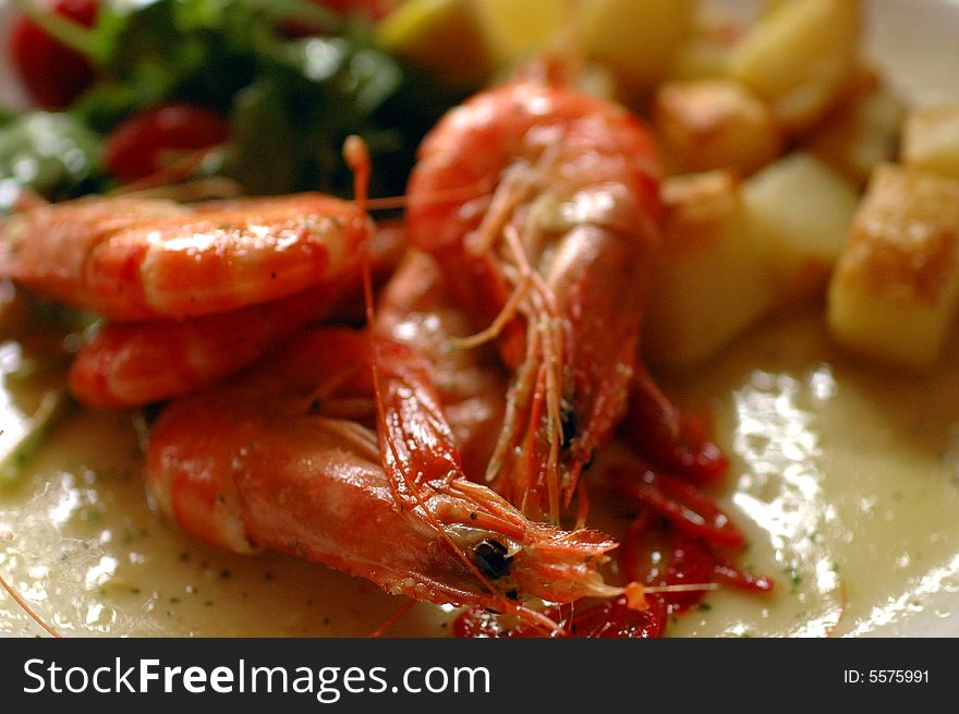 Colourful cooked shrimp on a plate as part of a meal.