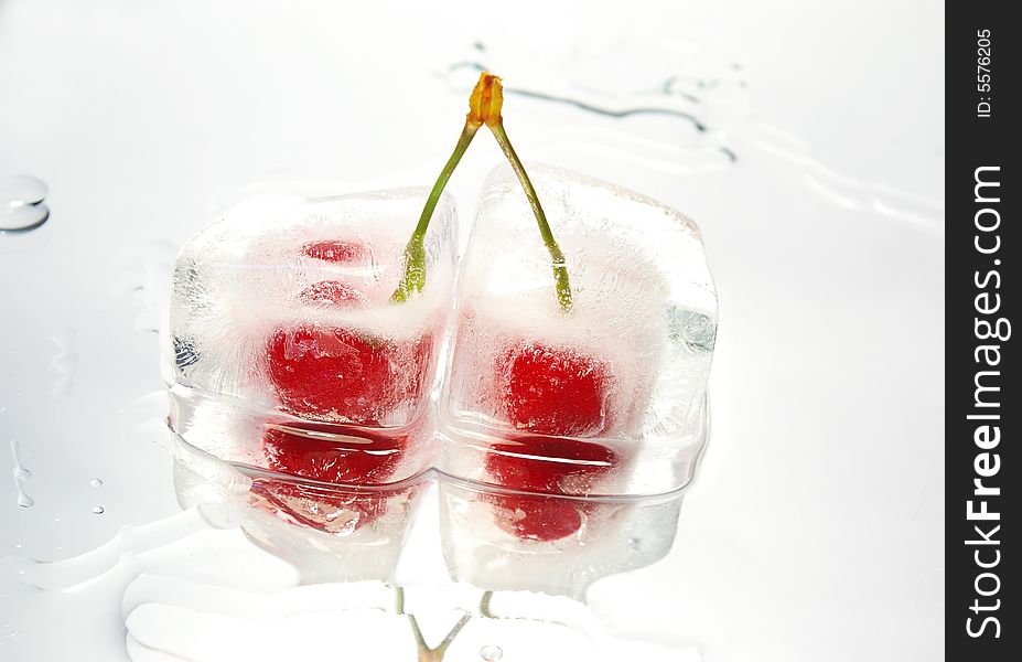 Two frozen cherries on white glass surface. Two frozen cherries on white glass surface