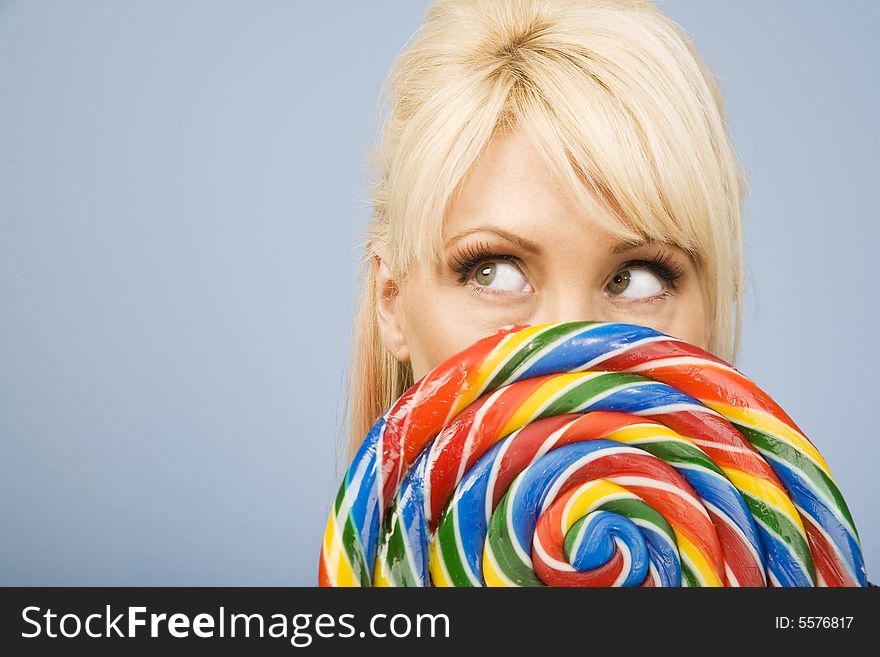 Woman holding a big colorful lollipop. Woman holding a big colorful lollipop
