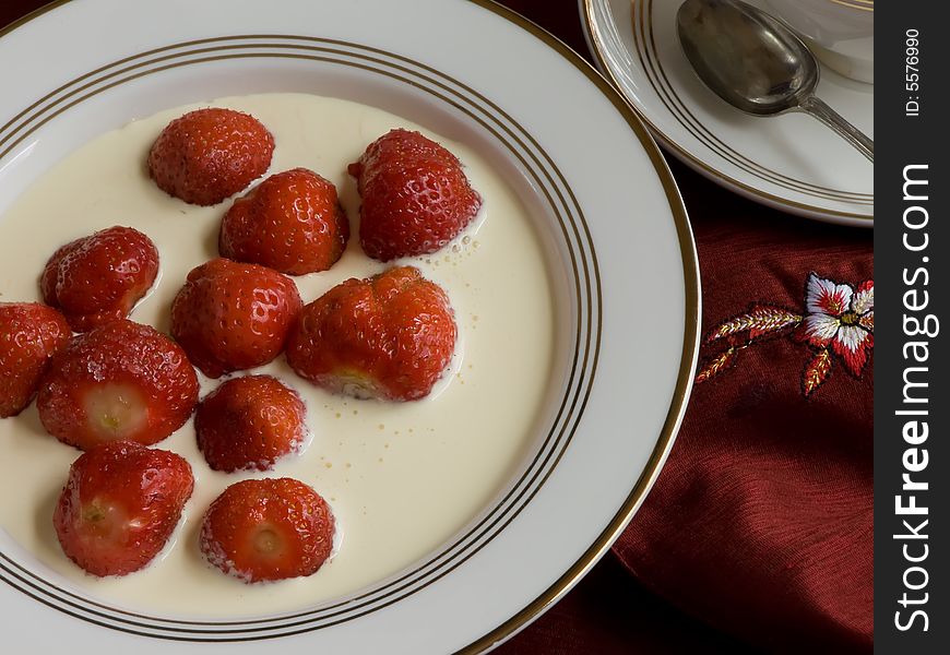 Strawberries and cream on plate with a red nepkin close. Strawberries and cream on plate with a red nepkin close.