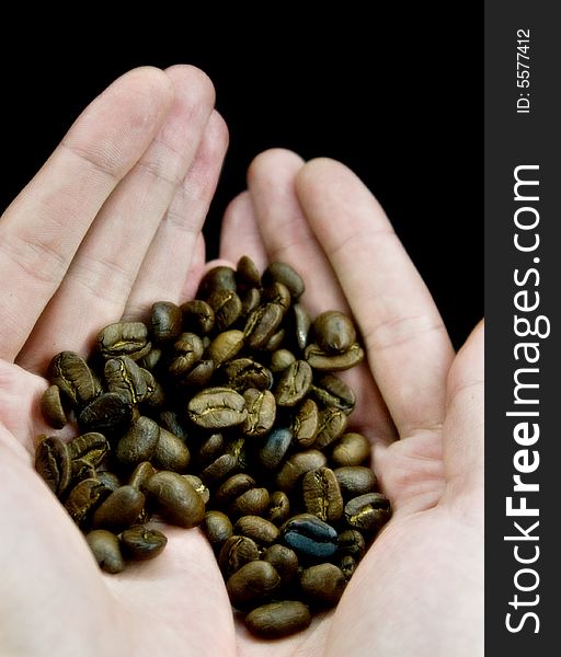 a handful of coffee beans on a black background. a handful of coffee beans on a black background