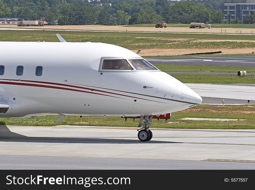 The nose of a large white private jet on the runway. The nose of a large white private jet on the runway