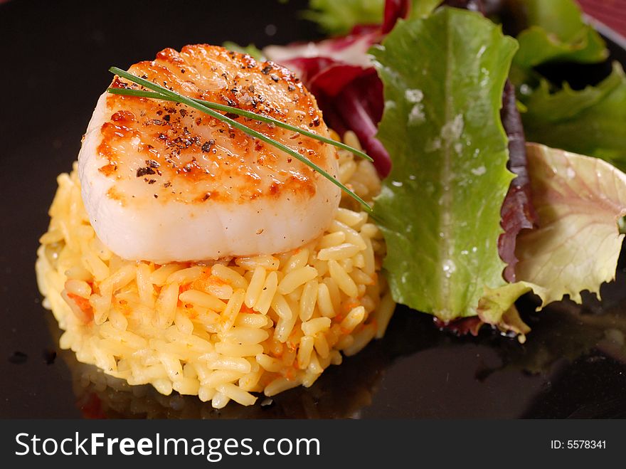 Scallop on bed of saffron rice with salad