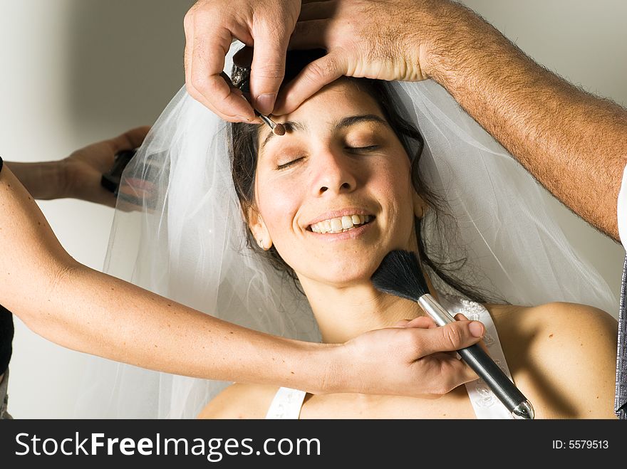 A woman smiling, while getting her make-up done. - horizontally framed. A woman smiling, while getting her make-up done. - horizontally framed