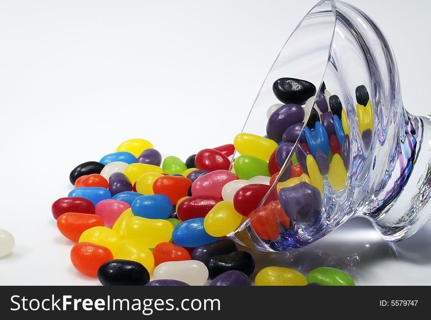 Spilt bowl of jelly beans on a white background