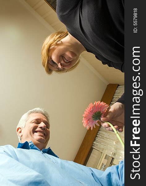 Older Couple Smiling Holding a Flower