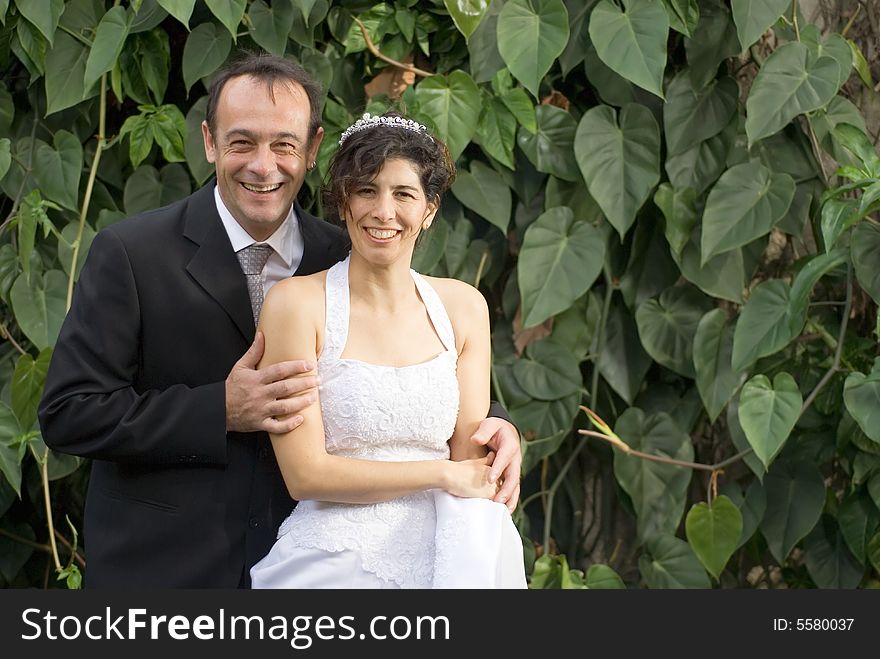 A newly married couple smile at the camera, while in their wedding clothes. - horizontally framed. A newly married couple smile at the camera, while in their wedding clothes. - horizontally framed