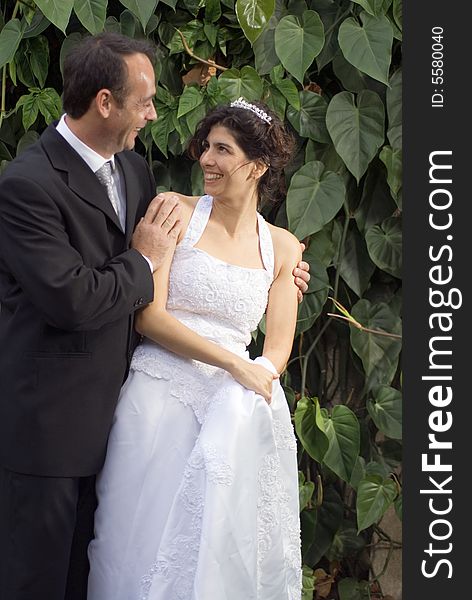 A newly married couple stare at each other, while in their wedding clothes. - vertically framed. A newly married couple stare at each other, while in their wedding clothes. - vertically framed