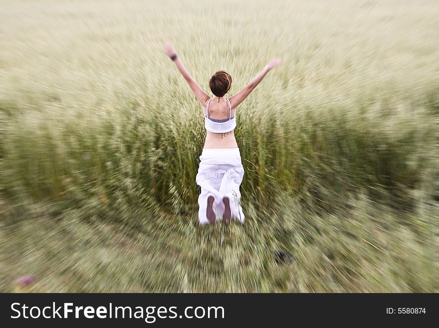 Young blond woman jumping in meadow.