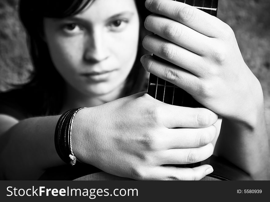 Woman holding guitar, black and white.