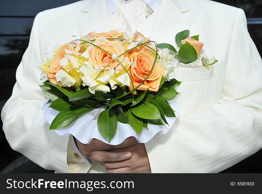 Groom in luxurious wedding suit with wedding bouquet. Groom in luxurious wedding suit with wedding bouquet
