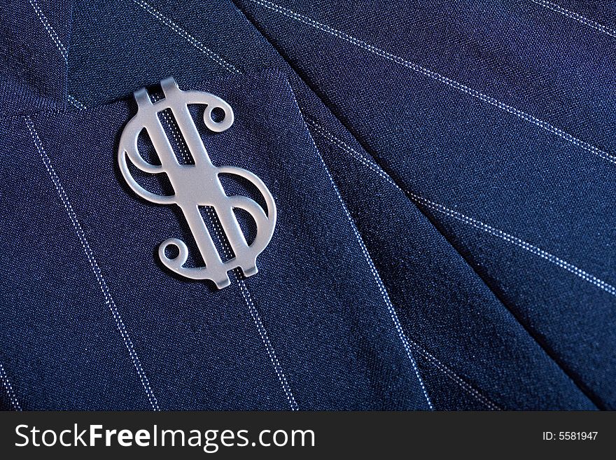 The sign on dollar is clamped on a collar of a jacket. The sign on dollar is clamped on a collar of a jacket