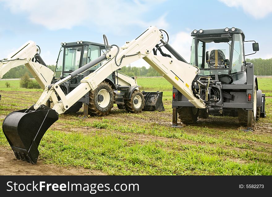 Two modern excavators on the field. Two modern excavators on the field