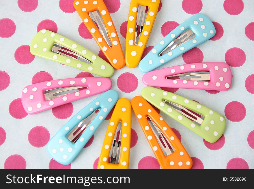 Brightly colored polka dot hair accessories on a polka dot background