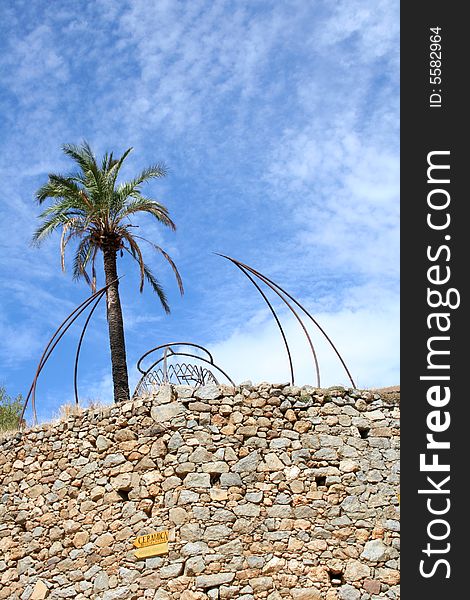 A palm on a brick wall, with sky background. A palm on a brick wall, with sky background