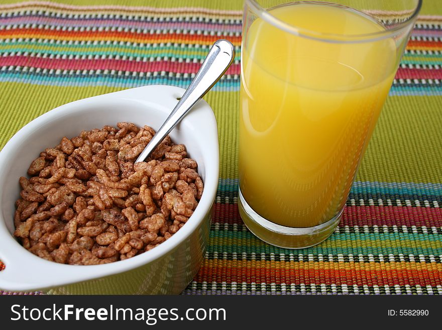Cereal in a green bowl with orange juice. Cereal in a green bowl with orange juice